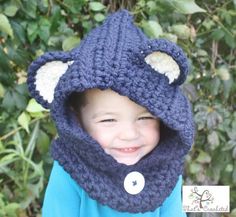 a young boy wearing a crocheted bear hat and scarf with ears on it