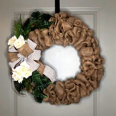 a burlock wreath with white flowers and greenery hangs on the front door