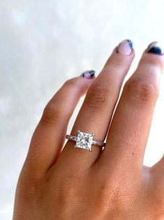 a woman's hand with a ring on her finger and a diamond in the middle