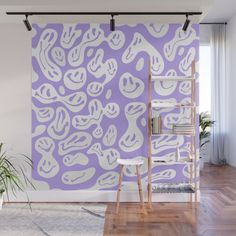 a pink and white abstract wall mural in an empty room with wooden flooring, planters and bookshelves