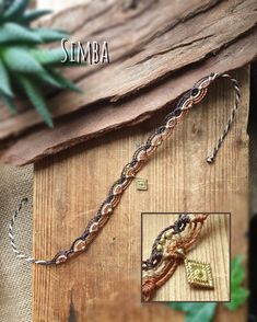 some beads are hanging from a piece of wood with the words simba on it