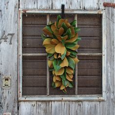 a wreath hanging on the side of a wooden door with metal grates around it