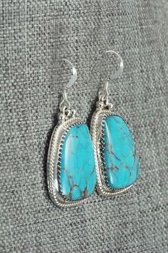 These Kingman turquoise and sterling silver earrings were made by Navajo silversmith Sharon McCarthy. The back is signed RB and stamped .925.Length: 1 1/2"Width: 3/4"Free shipping on all orders! We ship with USPS and always include tracking. All orders ship within a day of payment.Returns are accepted up to 30 days after you receive your order. Just send us a message. Our shop offers cash back or store credit. The item must be returned in new condition. Nickel Free Sterling Silver Western Earrings, Handmade Western Turquoise Earrings, Handmade Southwestern Sterling Silver Earrings, Turquoise Dangle Earrings Western Style, Western Turquoise Dangle Earrings, Nickel-free Turquoise Beaded Earrings In Sterling Silver, Western Style Turquoise Nickel-free Earrings, Western Turquoise Nickel-free Earrings, Turquoise Nickel-free Southwestern Teardrop Earrings