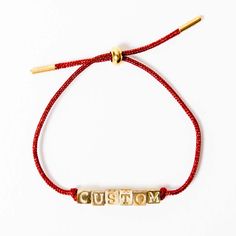 Our Goldie Custom cord bracelet offers a touch of nostalgic charm with a modern twist. Crafted with a shimmering cord and brass letter beads, it evokes the classic friendship bracelets of your childhood, reimagined for a chic, grown-up aesthetic. Select up to 10 characters to create your personalized design. The beads are securely knotted in place, ensuring your chosen word or name stays put. PERMITTED CHARACTERS AND SYMBOLS - Letters: A-Z (uppercase)- Special characters: plus sign (+), blank bead (simply type a space and we will insert a blank bead)- Symbols: heart (♡)- Character limit: 10 Final Sale Custom products are final sale and not eligible for returns. Your order cannot be canceled or altered once submitted. We reserve the right to cancel any order that violates any intellectual p Heart Character, Sequin Bracelet, Beaded Hat Bands, Plus Sign, Word Bracelet, 18k Gold Earrings, Ring Bag, Cord Bracelet, Letter Beads