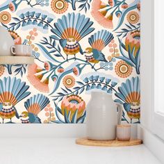 a white vase sitting on top of a counter next to a blue and orange wallpaper