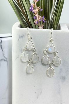 Connect with your inner natural beauty with our authentic Moonstone Earrings - Dew Drops. Sleek, stylish and feather-light, these pretty dangle earrings reflect the effortless beauty that comes from within. A statement such as our Dew Drops will take you from airy summer picnics to cozy winter get-togethers in style. A striking addition on their own or matched with your Dew Drops Necklace, these enchanting earrings are sure to become a favorite. Authentic Sivalya Moonstone Moonstone: Goddess Ene White Teardrop Sterling Silver Chandelier Earrings, Elegant White Moon Phase Earrings, Drop Moonstone Earrings With Natural Stones, White Moonstone Dangle Crystal Earrings, White Moonstone Long Drop Earrings, Pretty Dangle Earrings, Pretty Earrings Dangle, Drops Necklace, Summer Picnics