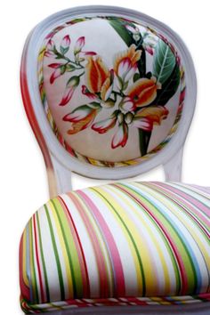 an upholstered chair with flowers painted on the back and seat cushion is shown