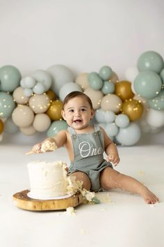 a baby sitting in front of a cake