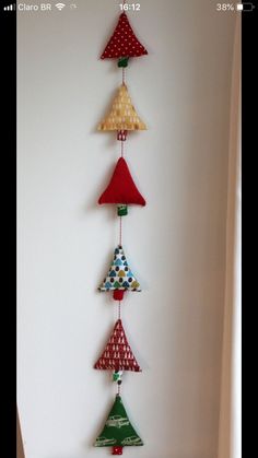 a wind chime hanging from the side of a white wall with red, green and blue decorations