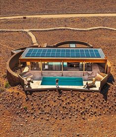 an aerial view of a house with a solar panel on the roof and swimming pool