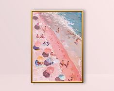 a painting hanging on the wall next to a pink wall with an ocean and beach scene