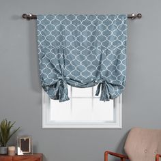 a window with a blue and white patterned valance hanging from it's side