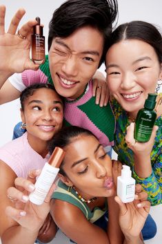 three people posing for the camera with some skin care products in front of their faces