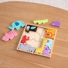 a wooden puzzle with animals and giraffes in it on top of a table