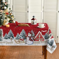 a christmas table cloth with a snowman and sleigh in front of a tree