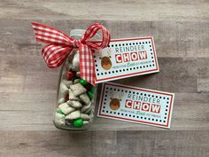 two glass jars filled with candy sitting on top of a wooden table next to each other