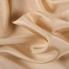 a close up view of a beige fabric with very soft folds and smooth lines on it