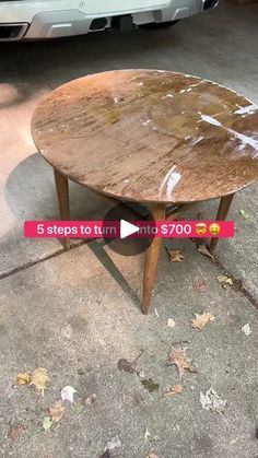 a wooden table sitting on top of a cement floor next to a white car parked in front of it