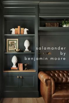 a brown leather couch sitting in front of a book shelf