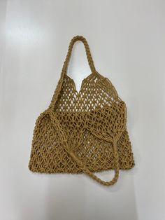 a crocheted bag hanging on the wall with no strings attached to it's handles