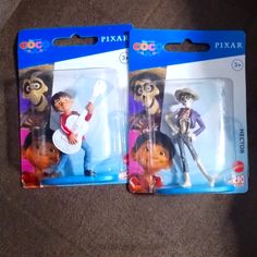 two toy figurines of the same character are shown in their packaging on carpet