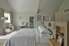 a bedroom with a bed, dresser and chair next to a window in the room