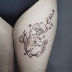 a woman's thigh with an image of a cat and flowers on the side