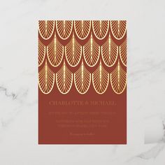 a red and gold wedding card with an intricate pattern on the front, featuring leaves