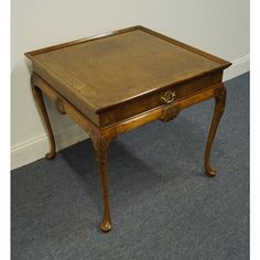 a small wooden table sitting on top of a carpeted floor