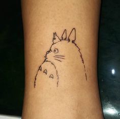 a small tattoo on the ankle of a person with a cat and dog drawn on it