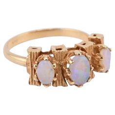 This is a gorgeous 14 karat yellow gold opal ring. There are three gorgeous white opals with a decent amount of fire. It has a unique intricate design. The weight of the ring is 2.78 grams and the ring size is 5 1/2. The condition is excellent. It is ready to go. If you have any questions or any concerns, please ask. Yellow Gold Opal Ring, Opal Solitaire Ring, Retro Bracelet, Yellow Gold Solitaire, Black Opal Ring, Diamond Free, Emerald Diamond Ring, Opal Ring Gold, Gold Cocktail