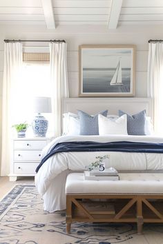 a bedroom with white furniture and blue accents