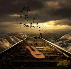 a guitar sitting on top of train tracks with music notes flying above it and mountains in the background