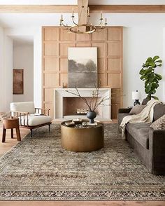 a living room filled with furniture and a large rug on top of a wooden floor