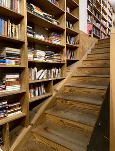 there are many books on the shelves in this library and stairs lead up to them