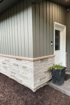 a house with a planter in front of it and a door on the side