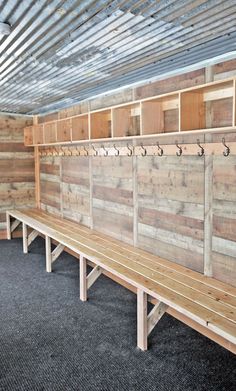 a long wooden bench sitting inside of a building