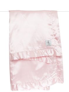 a pink blanket with ruffled edges and a white tag on the bottom of it