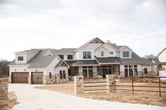 a large house with lots of windows in the front and side of it on a cloudy day