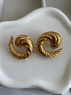 ✨Embrace the art of seduction with our Taylor Gold Earrings. ✨These stunning pieces are a masterclass in modern elegance, featuring a twisted, spiral design that wraps around your earlobe with a sultry allure. ✨The Taylor earrings are not just an accessory—they're an invitation to indulge in your most glamorous fantasies. ✨Their bold, sculptural form creates a mesmerizing effect, ensuring all eyes are on you. Perfect for the woman who dares to stand out, these earrings are the ultimate statement of confidence and style. ✨Let your presence be unforgettable with the Taylor Gold Earrings. Elegant Gold Spiral Wrap Earrings, Modern Spiral Earrings For Formal Occasions, Elegant Spiral Earrings As Gift, Elegant Spiral Wrap Earrings, Elegant Spiral Metal Jewelry, Elegant Swirl Earrings, Elegant Twisted Earrings For Pierced Ears, Elegant Spiral Hoop Earrings For Gift, Elegant Spiral Hoop Earrings As Gift