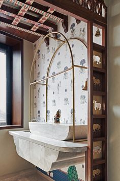 the bathroom is decorated with animal themed wallpaper and gold fixtures, along with a marble sink