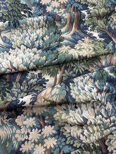 a blue and green floral fabric with trees on it