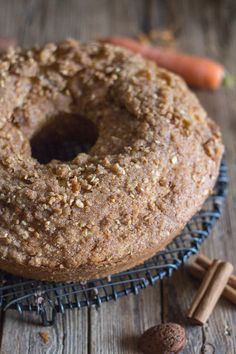 an easy carrot coffee cake is sitting on a cooling rack next to some carrots