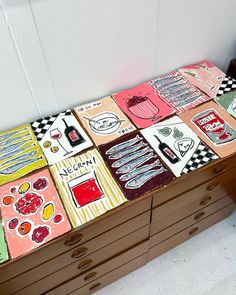 the drawers are made out of wood and have different designs on them, including food