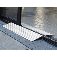 two ramps shown on the ground in front of a store window with an open door