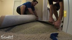 two men working on an area rug in a room that is being remodeled with carpet