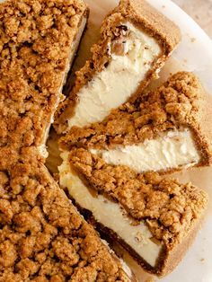 a white plate topped with slices of cake covered in crumbs and cream cheese