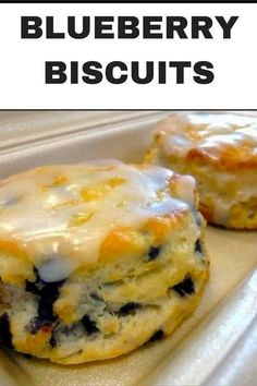 two blueberry biscuits sitting on top of a white tray with the words blueberry biscuits next to it