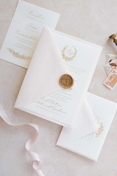 the wedding stationery is laid out on top of each other, including a wax stamp