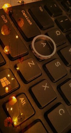 a close up of a computer keyboard with some lights on the keys and one key missing